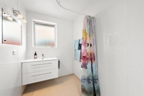 a bathroom with a sink and a shower curtain at 3 bedroom hidden gem in Gore