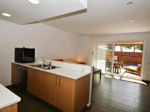 a kitchen with a sink and a living room at Casa Rosalia in Roda de Bará