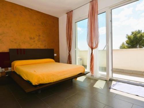 a bedroom with a bed and a large window at Casa Rosalia in Roda de Bará