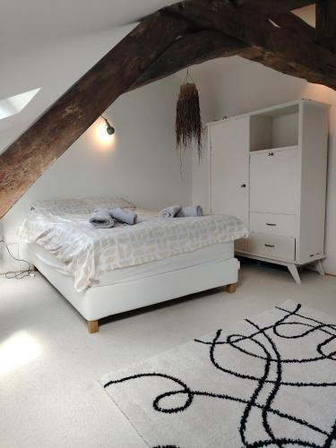 a bedroom with a white bed in a attic at Nouveau - Maison de charme - Centre de Bourdeilles in Brantome en Perigord