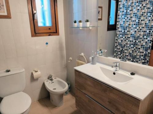 a bathroom with a white toilet and a sink at Casa Marti in Roda de Bará