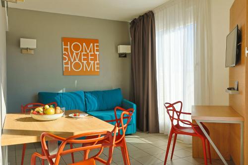 a living room with a blue couch and a table and chairs at Residhotel Le Grand Prado in Marseille