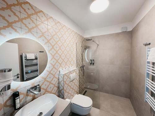 a bathroom with a sink and a toilet and a mirror at Hotel Oskar Zaplata in Preddvor