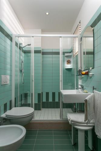 ein Badezimmer mit Dusche, Waschbecken und Toilette in der Unterkunft Hotel Gattuccio in Cesenatico