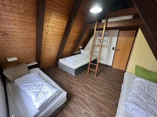 a room with two beds and a ladder in it at Ferienhaus Hasenglück in Waldbrunn