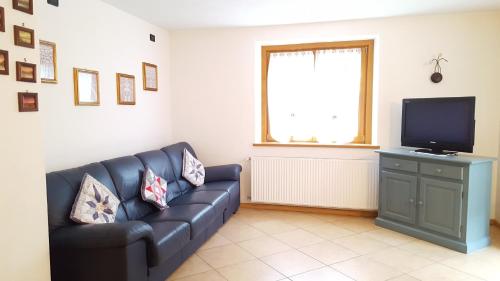 a living room with a couch and a television at Casa Rossi in Le Grazie