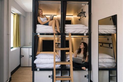two women sitting in bunk beds in a room at Latroupe Jacobs Inn in Dublin