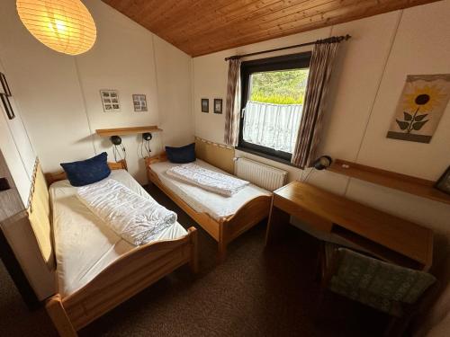 a small room with two beds and a window at Ferienhaus Morgentau in Waldbrunn