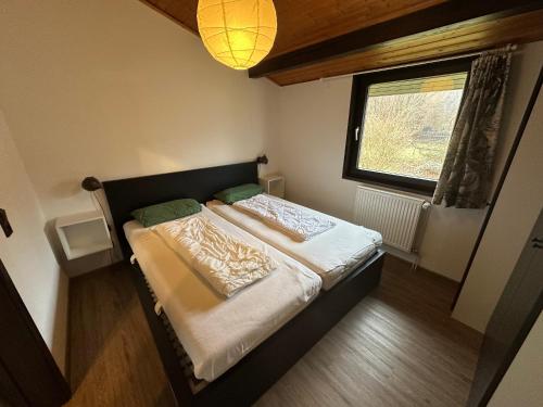 a small bedroom with a bed and a window at Ferienhaus Mooswinkel in Waldbrunn