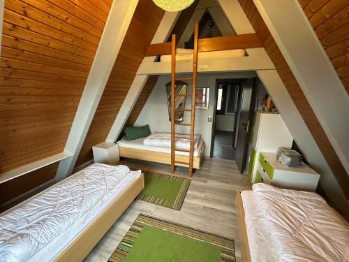 two beds in a room with wooden ceilings at Ferienhaus Schneekristall in Waldbrunn