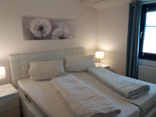 a white bed in a room with two pillows at Ferienhaus Krappennest in Waldbrunn