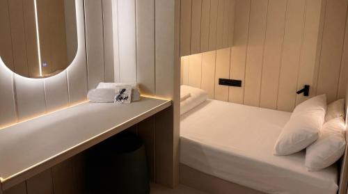 a small bathroom with a bed and a mirror at Wostel The Comfort Hostel in Málaga
