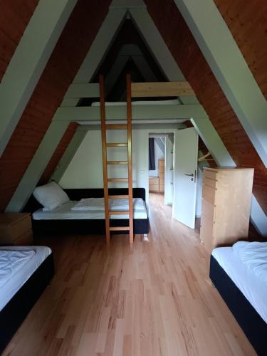 a room with two beds and a ladder at Ferienhaus Glücksgefühle in Waldbrunn