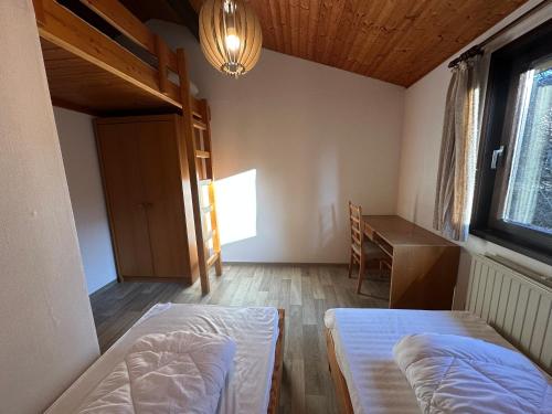 a room with two beds and a desk and a window at Ferienhaus Abendstille in Waldbrunn