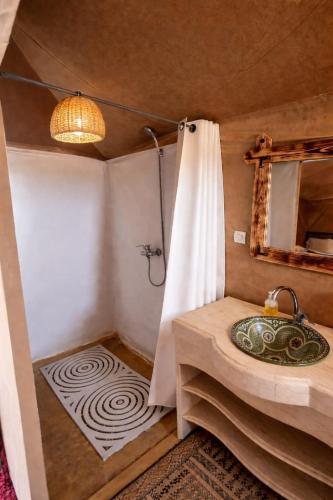 a bathroom with a sink and a shower in a room at Sahara wellness camp in Merzouga