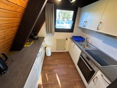 a small kitchen with white cabinets and a sink at Ferienhaus Winterruhe in Waldbrunn