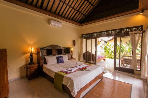 ein Schlafzimmer mit einem großen Bett in einem Zimmer in der Unterkunft Jagi Villa in Ubud