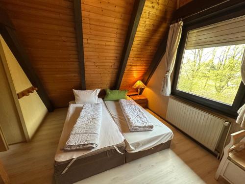 a bedroom with a bed in a room with a window at Ferienhaus Abendzauber in Waldbrunn