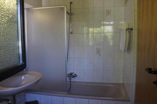 a bathroom with a tub and a sink and a shower at Ferienhaus Urlaubsfreude in Waldbrunn