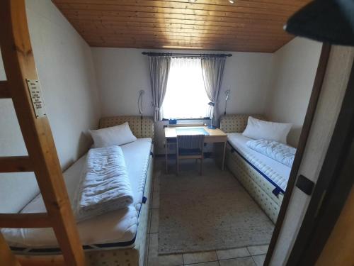 a small room with two beds and a desk at Ferienhaus Romantiklicht in Waldbrunn