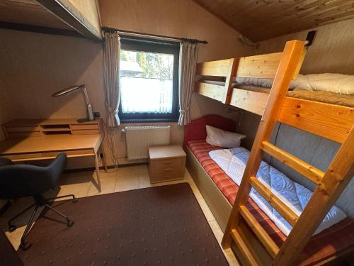 a dorm room with a desk and bunk beds at Ferienhaus Romantiknest in Waldbrunn