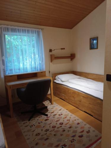 a bedroom with a desk and a bed and a chair at Ferienhaus Romantikruhe in Waldbrunn