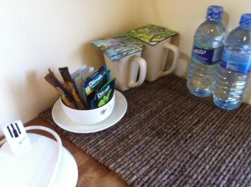 a table with a cup of pens and two bottles of water at Witherspoon Lodge in Kandy