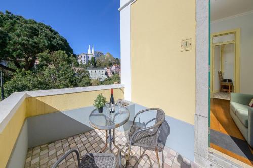 a table and chairs on a balcony with a view at Casa Mariana 1 - Sintra, Pena Palace & Castle Views, Terrace Apartment in Sintra