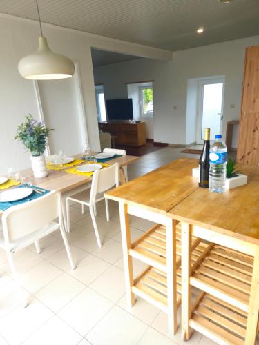 a kitchen and dining room with a wooden table and chairs at Residencias Requinte T3 Espacoso com Terraco e Vista in São Roque do Pico