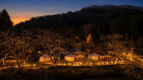 a group of tents with lights at night at みどりの村 in Ogano