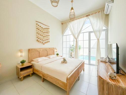 a bedroom with a large bed and a large window at At Paviliun With Private Pool in Timuran