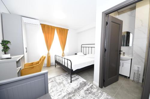a bedroom with a bed and a sink and a mirror at Stay Inn in Galaţi