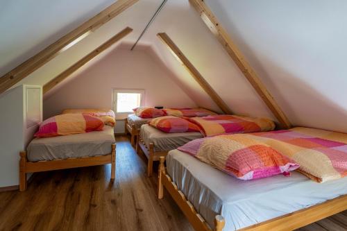 three beds in a room with a attic at Alpine Daffodil Retreat in Jesenice