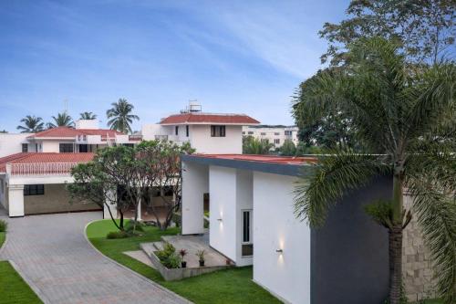 an exterior view of a house with palm trees at Sais lotus villa -Home stay and Event venue in Coimbatore