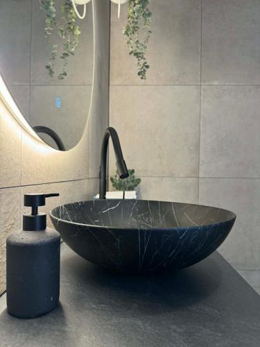 a bathroom with a black sink and a mirror at Old Town, The Reward apartment with terrace with a view in Staré Mesto