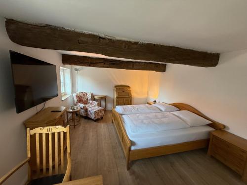 a bedroom with a bed and a tv and a chair at Hof König in Everswinkel