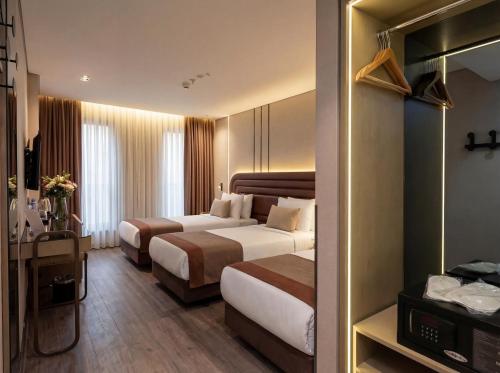 a hotel room with two beds and a mirror at Edition Old City Hotel in Istanbul