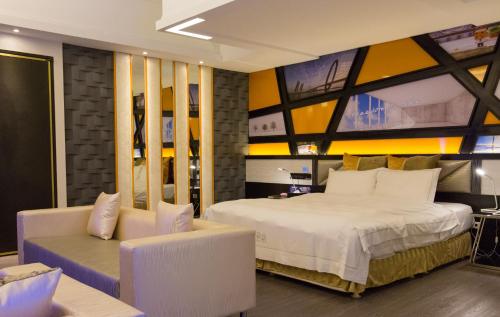 a bedroom with a large bed and a couch at Soho Motel in Taoyuan