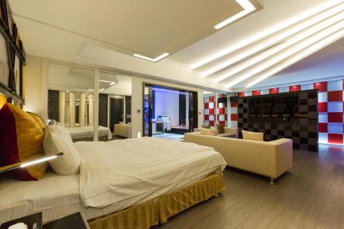 a bedroom with a large bed and a couch at Soho Motel in Taoyuan