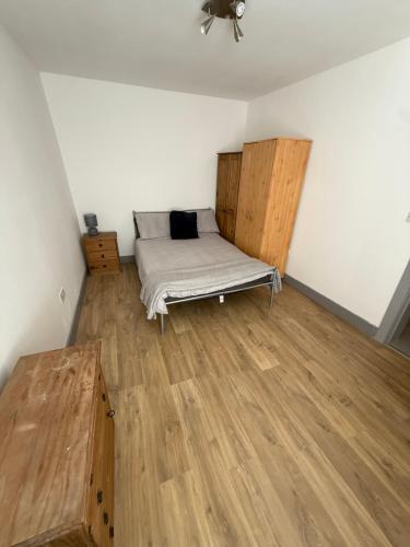 a bedroom with a bed and a wooden floor at Flat 4 Rylands Street in Warrington