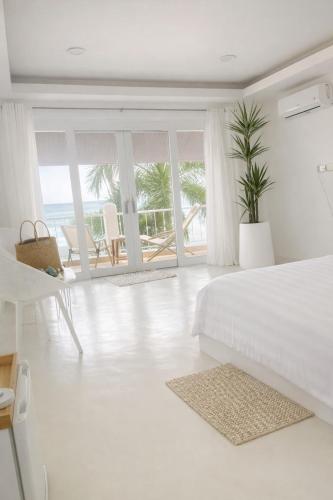 ein weißes Schlafzimmer mit Bett und Meerblick in der Unterkunft SOLEA Beach in Nathon Bay