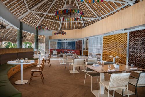 a restaurant with tables and chairs and a ceiling at Catalonia Royal Tulum Beach & Spa Resort Adults Only - All Inclusive in Xpu Ha
