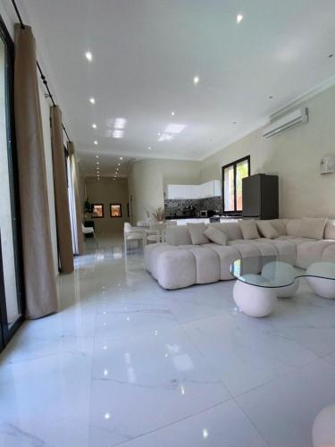 a large living room with a large couch and tables at Villa Marrakech ,Piscine Privée & Luxe Authentique in El Aggada