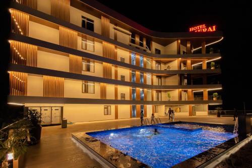 ein Hotel mit einem großen Swimmingpool vor einem Gebäude in der Unterkunft Hotel PUMERAI in Honāvar
