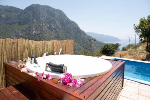 a bath tub sitting on a deck next to a pool at Kabak Freedom Deluxe Hotel in Faralya