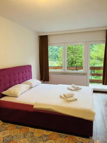 a bedroom with a large bed with a pink headboard at Mountain Holiday Homes in Kostel