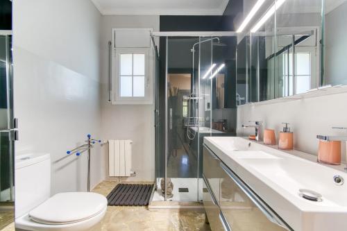 a bathroom with a toilet and a sink and a shower at Villa Aphrodite in Puigventos