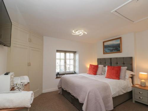 a bedroom with a large bed with red pillows at Isla cottage in Northallerton