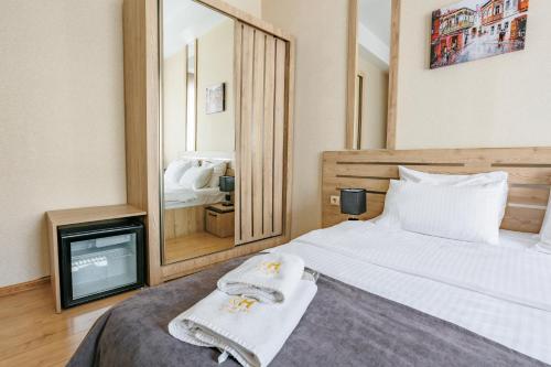 a bedroom with a bed and a mirror and a tv at City Heart Hotel in Tbilisi City
