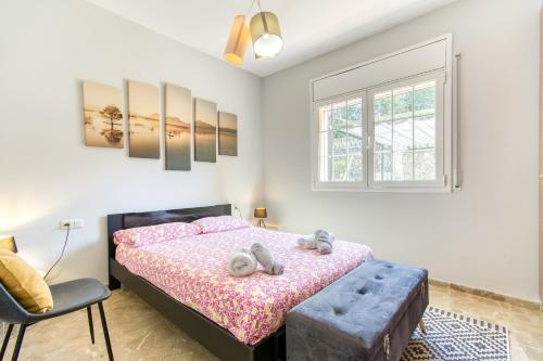 a bedroom with a bed and a chair and a window at Villa Aphrodite in Puigventos